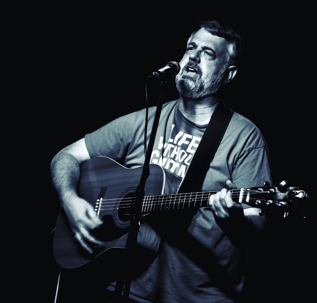 IMG_0272 Image of Jay Williams performing with an acoustic guitar.